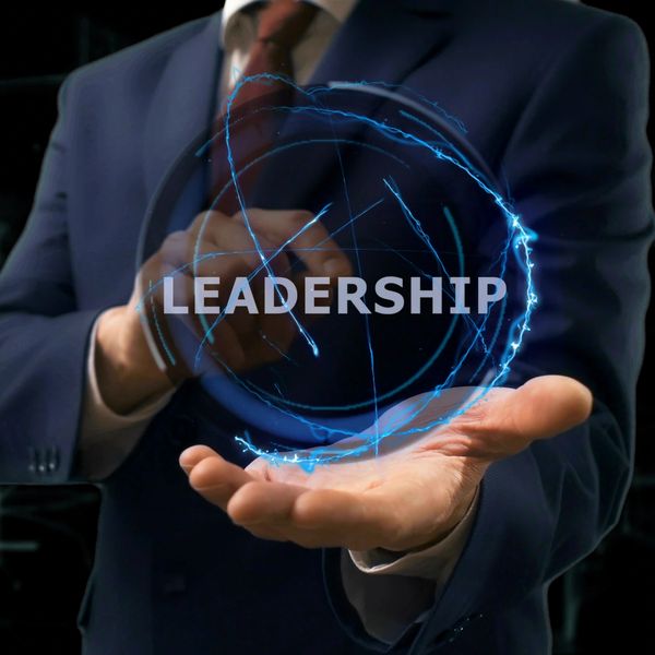 A man in a suit holding a glowing orb with 'LEADERSHIP' text.
