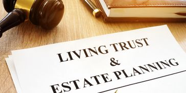 Legal documents for living trust and estate planning on a desk with a gavel and pen.