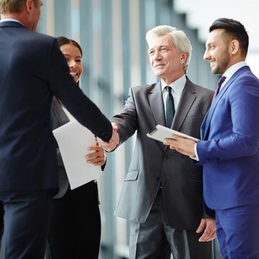 a quality collaborative lawyer with his client shaking hands with the other lawyer with his client