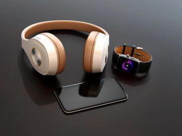 Headphones, smartwatch, and smartphone on a black surface.