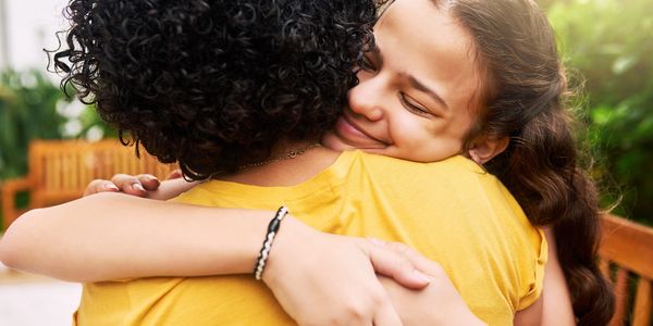 A young person hugging their mother