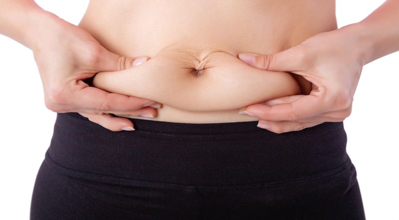 close up of woman pinching belly fat