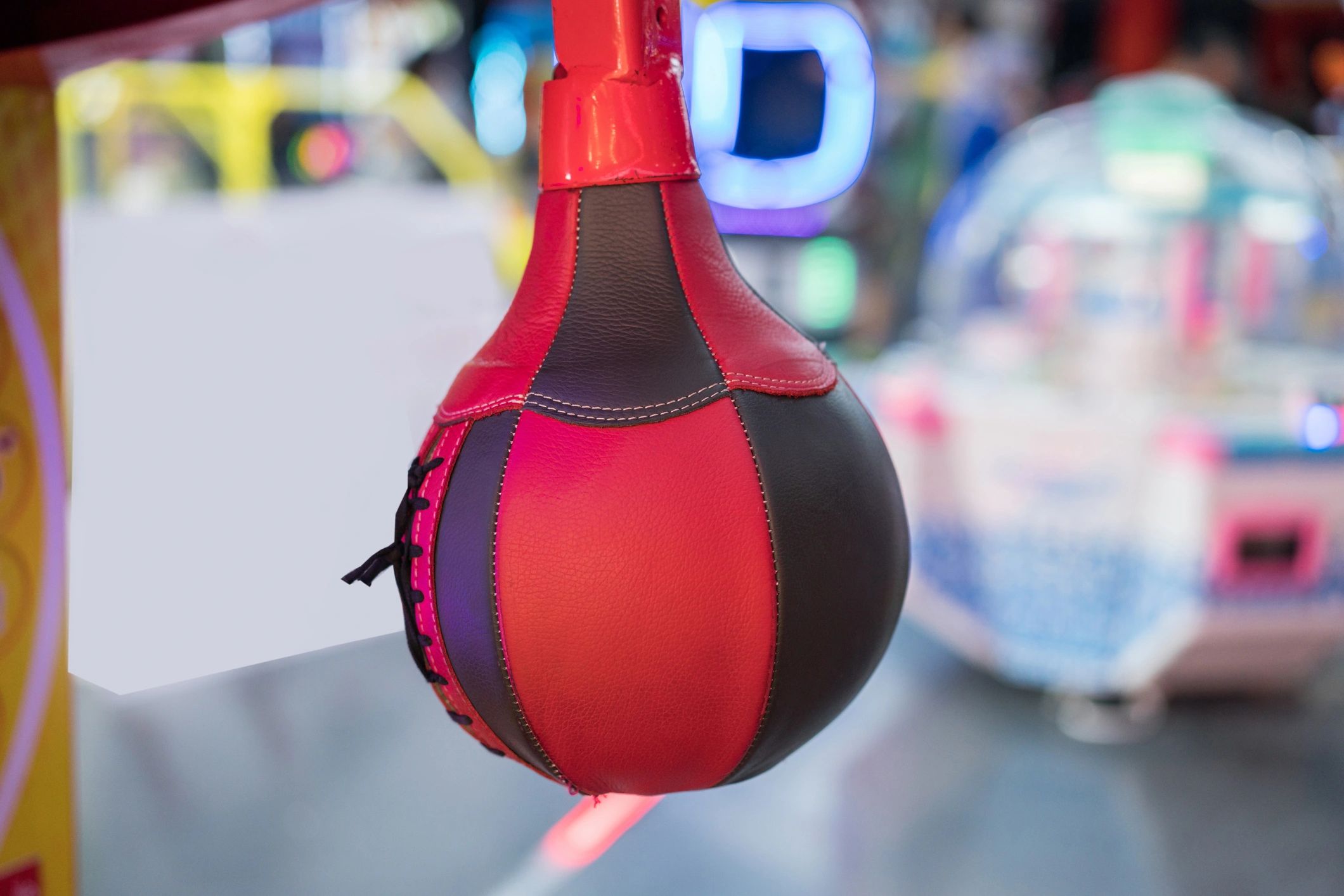 Close-up of a red and black speed bag in a gym or arcade.