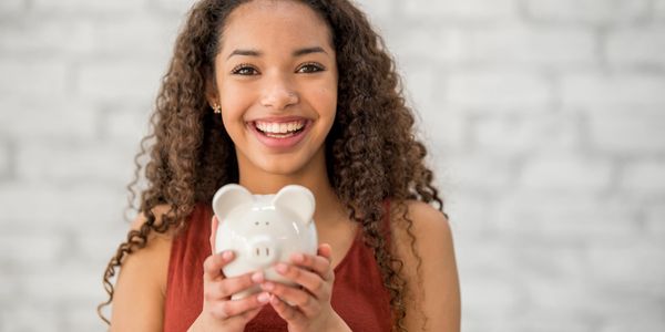 a teen happily smiling, a teen learning financial literacy