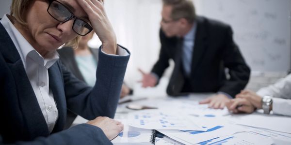 A photo of a woman business owner with her hand on her head worried about getting business funding 