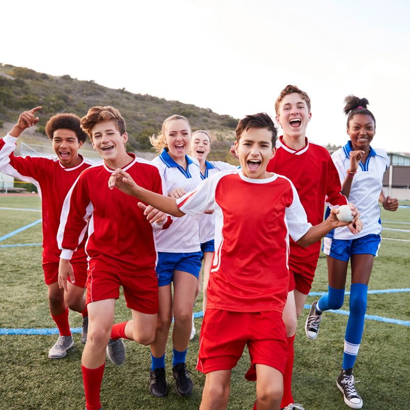 Portrait Of Male And Female High School Soccer Teams Celebrating