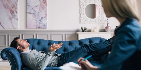 Man lying on couch receiving hypnotherapy