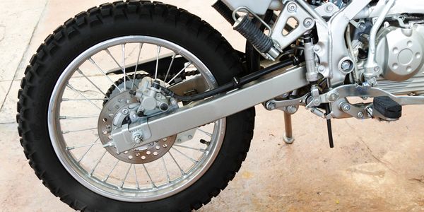 Close-up of a motorcycle's rear wheel and suspension system.