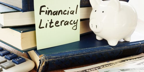 Books, a piggy bank, and a note labeled Financial Literacy.