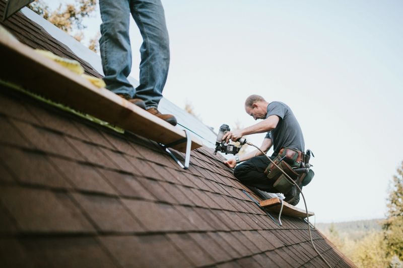 A roofer and crew work on putting in new roofing shingles.  Small local business serving local families in Washington State.