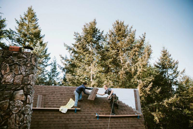 A roofer and crew work on putting in new roofing shingles.  Small local business serving local families in Washington State.
