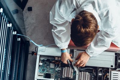 Technician repairing a server inside a data center rack.