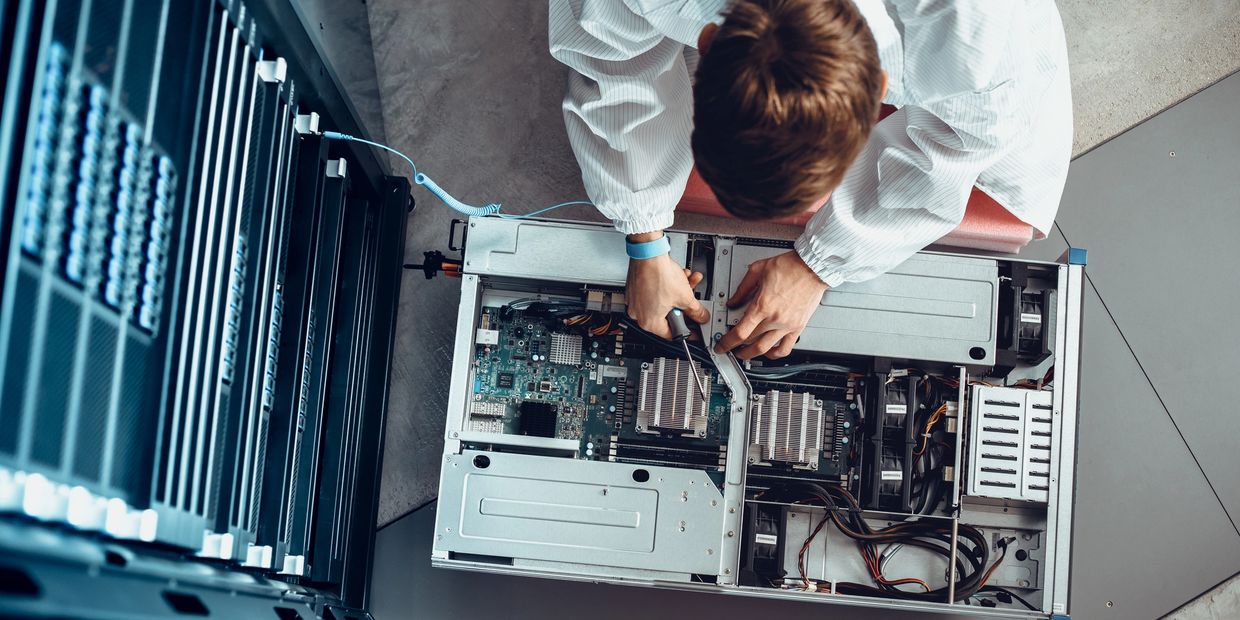 Technician repairing a server inside a data center rack.