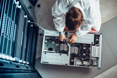 Technician repairing a computer's internal hardware.