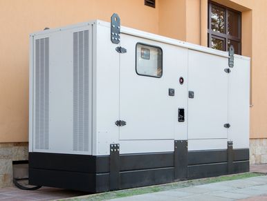 Large white industrial generator outside a building.