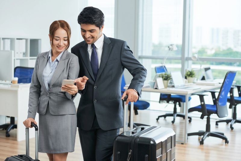 Business partners looking at the flight number on a mobile phone