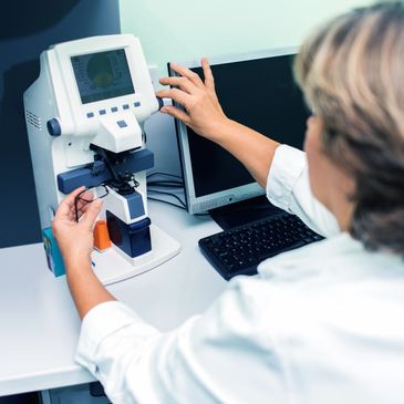 Eye specialist examining glasses with diagnostic equipment.