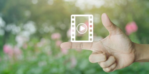 Hand gesture resembling a gun with a video play icon overlay.