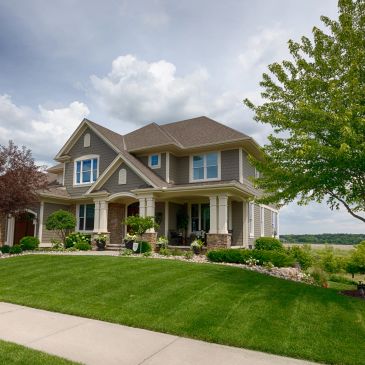 A large suburban house with a manicured lawn.
