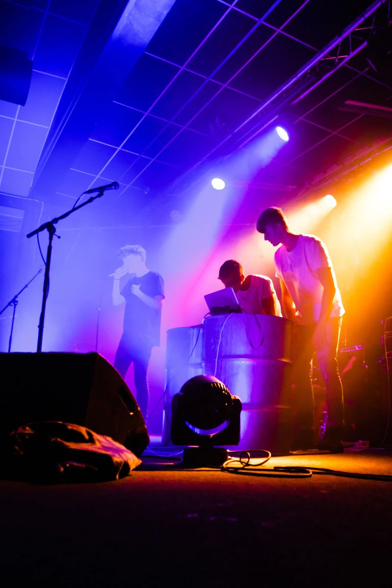 Young music rock band on the stage. Teenage group are making music, and are in love with it. Shoot with artificial light and stage light inside. The group of young people, are shoot in Denmark in colour / color. The teenagers are singing, jumping and playing on their instruments.