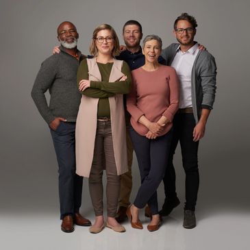 Five diverse adults standing together, smiling confidently against a neutral backdrop.
