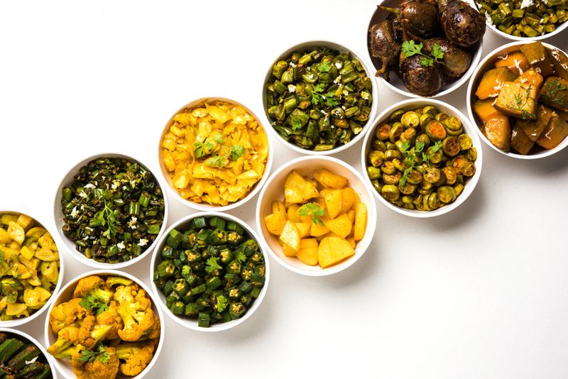 Indian sabzi / vegetable fried recipes served in white bowl over moody or colourful background. selective focus