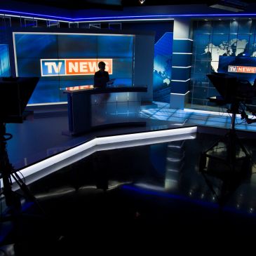 Studio de télévision moderne avec présentateur.
