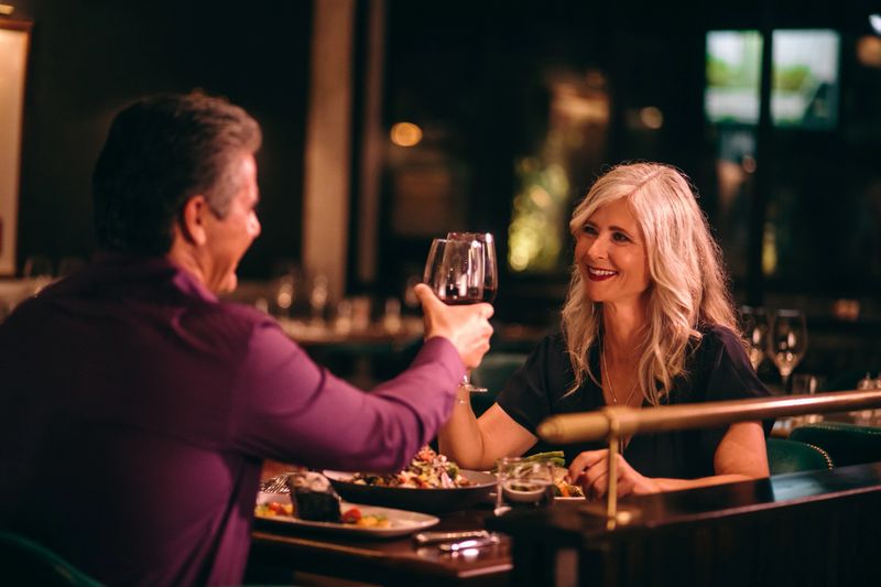 Senior couple in love toasting with red wine and having dinner at fine dining restaurant