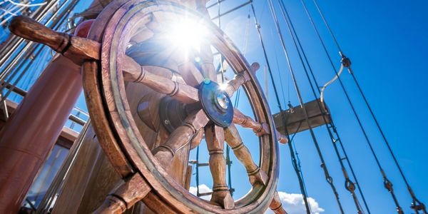 Sailboat wheel in the sunshine ready to navigate the path