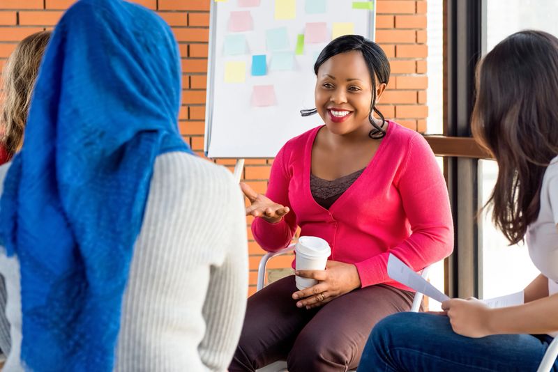 Diverse group of women in colorful clothes at the meeting, discussing social project