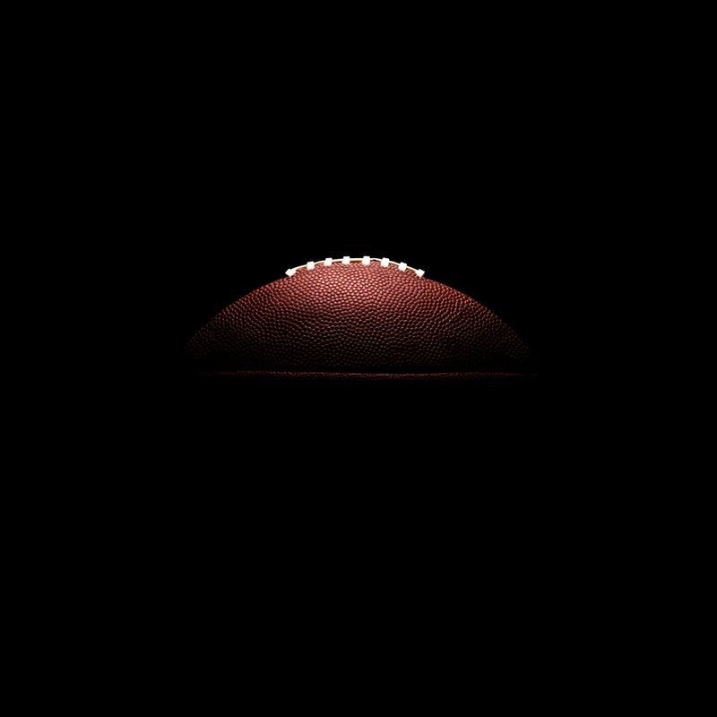 American football ball on black background