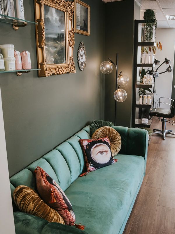 Cozy green velvet sofa with artistic eye pillows in stylish living room.
