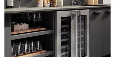 Modern kitchen cabinetry with built-in wine cooler and glassware storage.