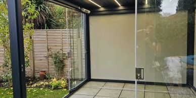 Empty modern glass room overlooking a garden.