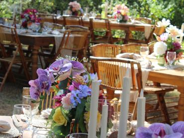 Elegant outdoor dining setup with floral centerpieces and candles.
