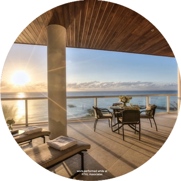 Sunset view from a modern balcony with outdoor seating and loungers.