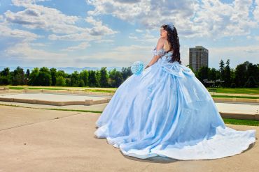 Mujer en vestido de princesa azul al aire libre.