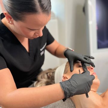 a picture of a woman getting a dermaplane facial