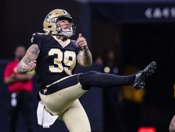 New Orleans Saints football player kicking the ball during a game.
