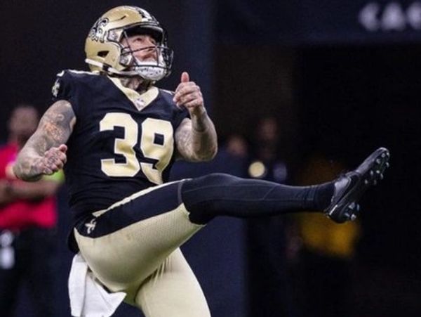 New Orleans Saints football player kicking the ball during a game.