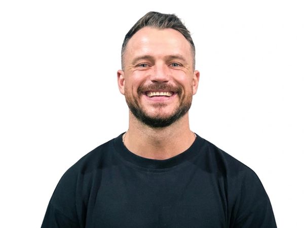 Smiling man wearing a black t-shirt with "Best Place On Earth" text.