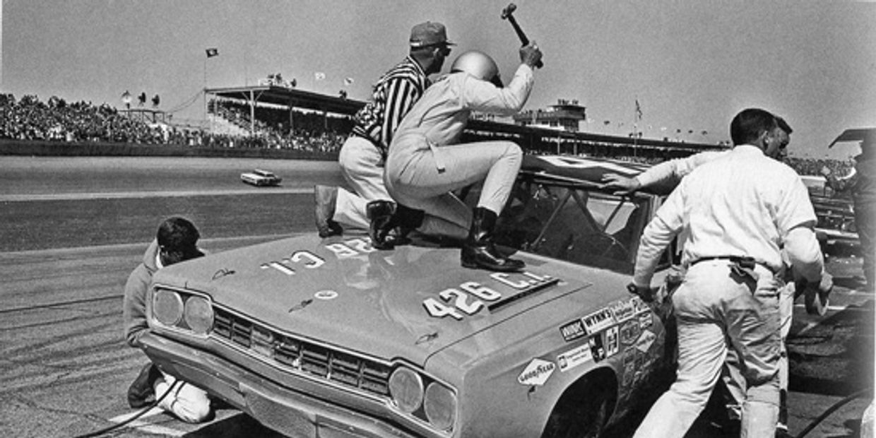 vintage black and white nascar pitstop man on hood swinging hammer