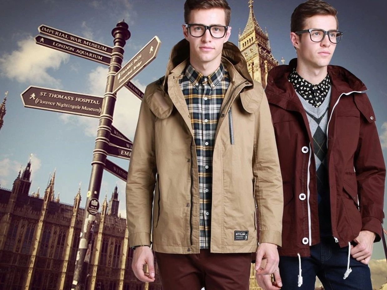 Two fashionable men wearing glasses and jackets with London landmarks in the background.