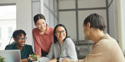 Four young professionals collaborating in a modern office space.