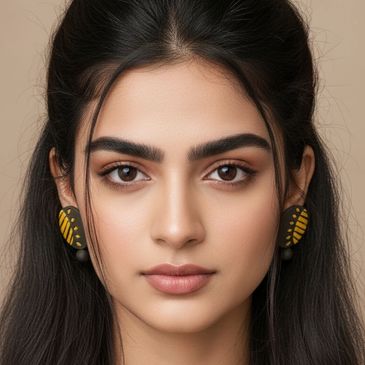 Close-up portrait of a woman with yellow and black earrings.