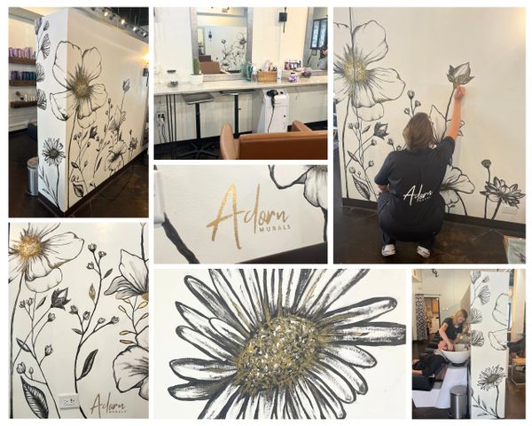 Artist painting gold-accented floral murals inside a salon.