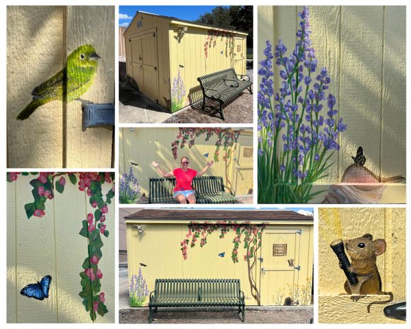 Colorful mural art of birds, butterflies, flowers, and a mouse on a yellow shed with a bench.