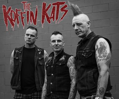 Three punk band members pose against a wall with The Koffin Kats logo.