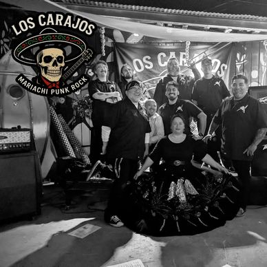 Black and white photo of a mariachi punk rock band posing together.