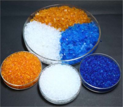 Colorful plastic pellets in transparent bowls arranged on a dark surface.
